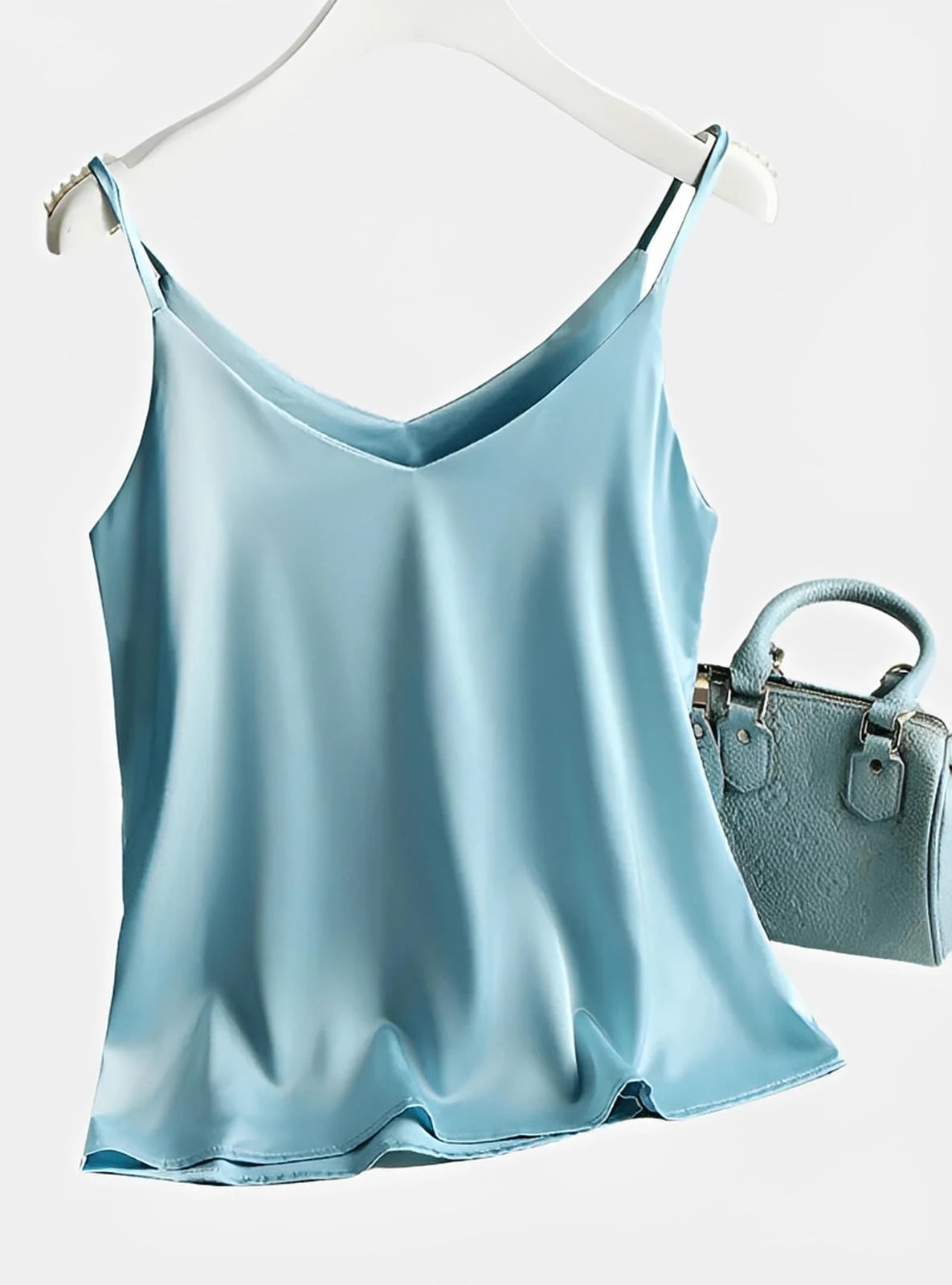 Light blue satin camisole top with thin straps and matching textured handbag